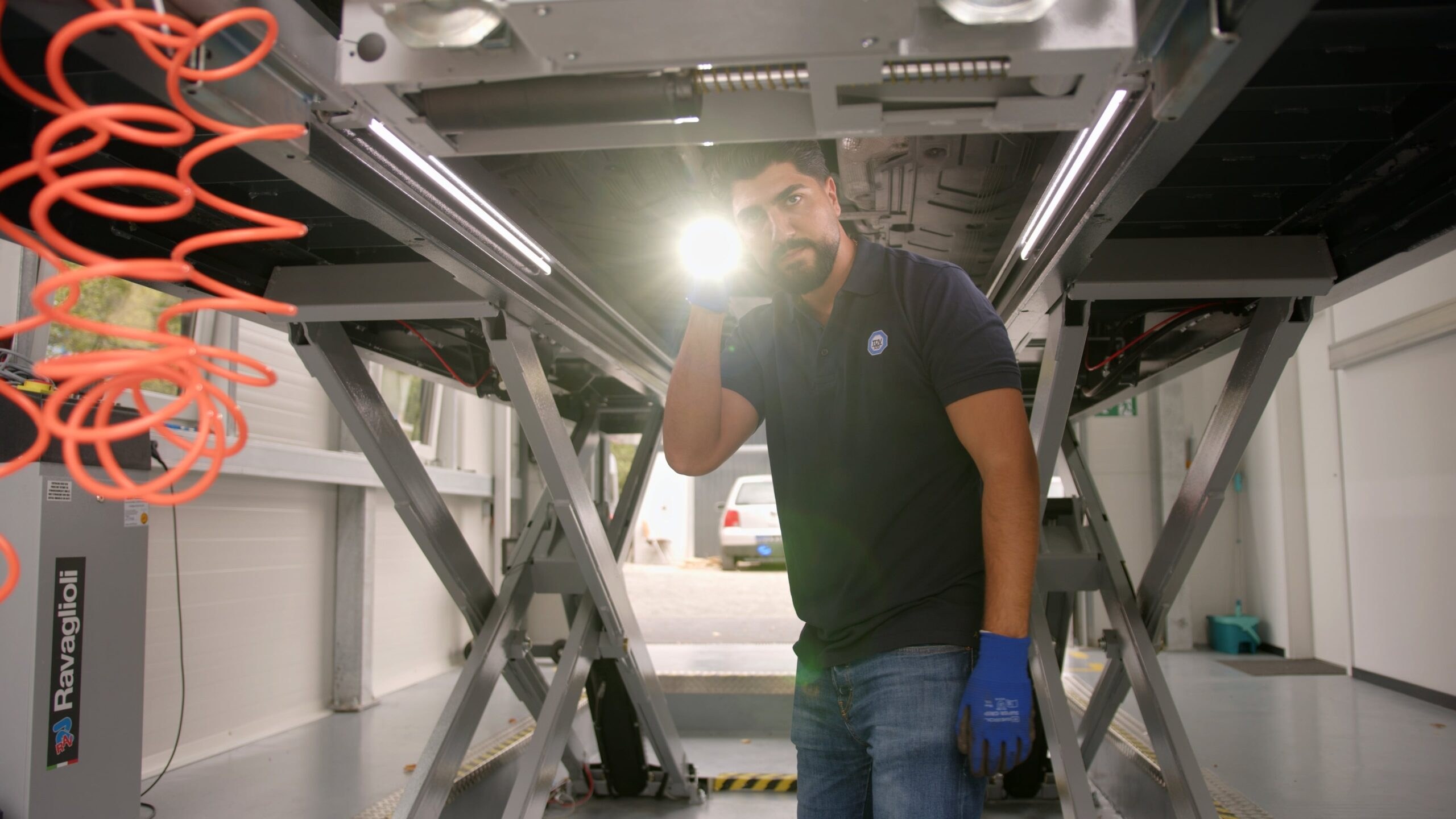 Professioneller KFZ-Prüfer bei der Fahrzeuginspektion in moderner Werkstatt